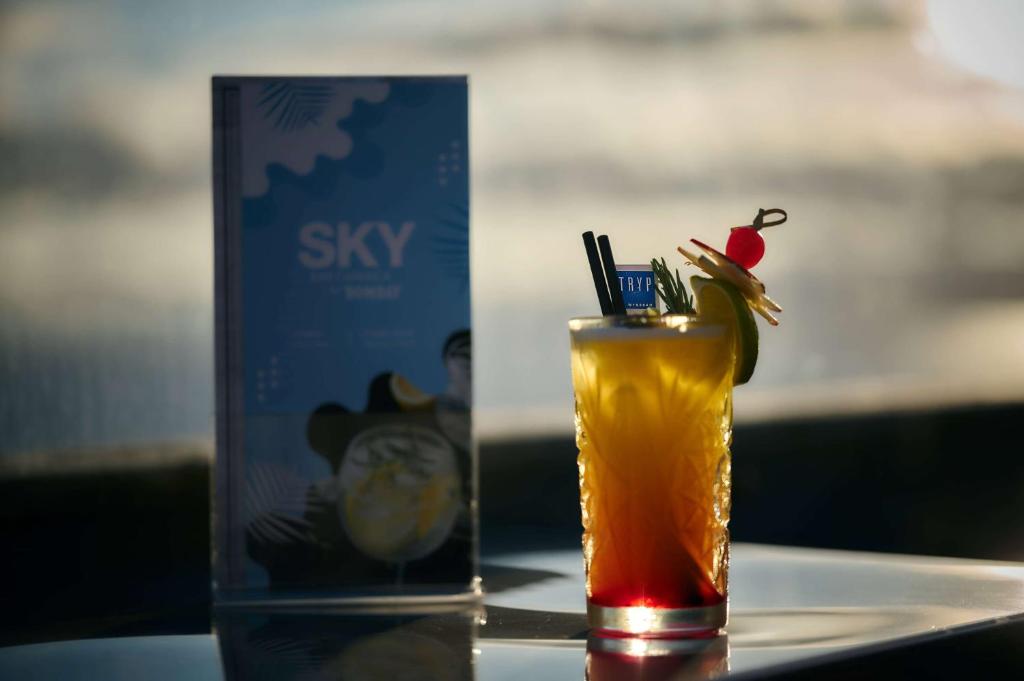 a drink sitting on a table next to a can of sky at TRYP by Wyndham Lisboa Caparica Mar in Costa da Caparica