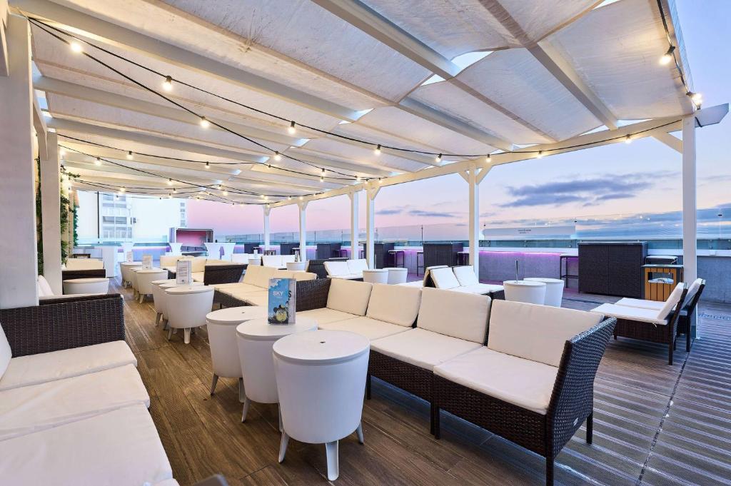 a restaurant with white tables and chairs on a deck at TRYP by Wyndham Lisboa Caparica Mar in Costa da Caparica