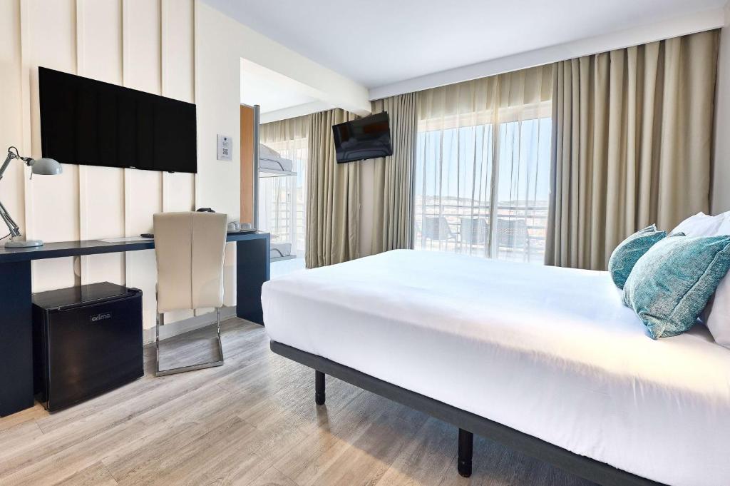 a hotel room with a large bed and a television at TRYP by Wyndham Lisboa Caparica Mar in Costa da Caparica