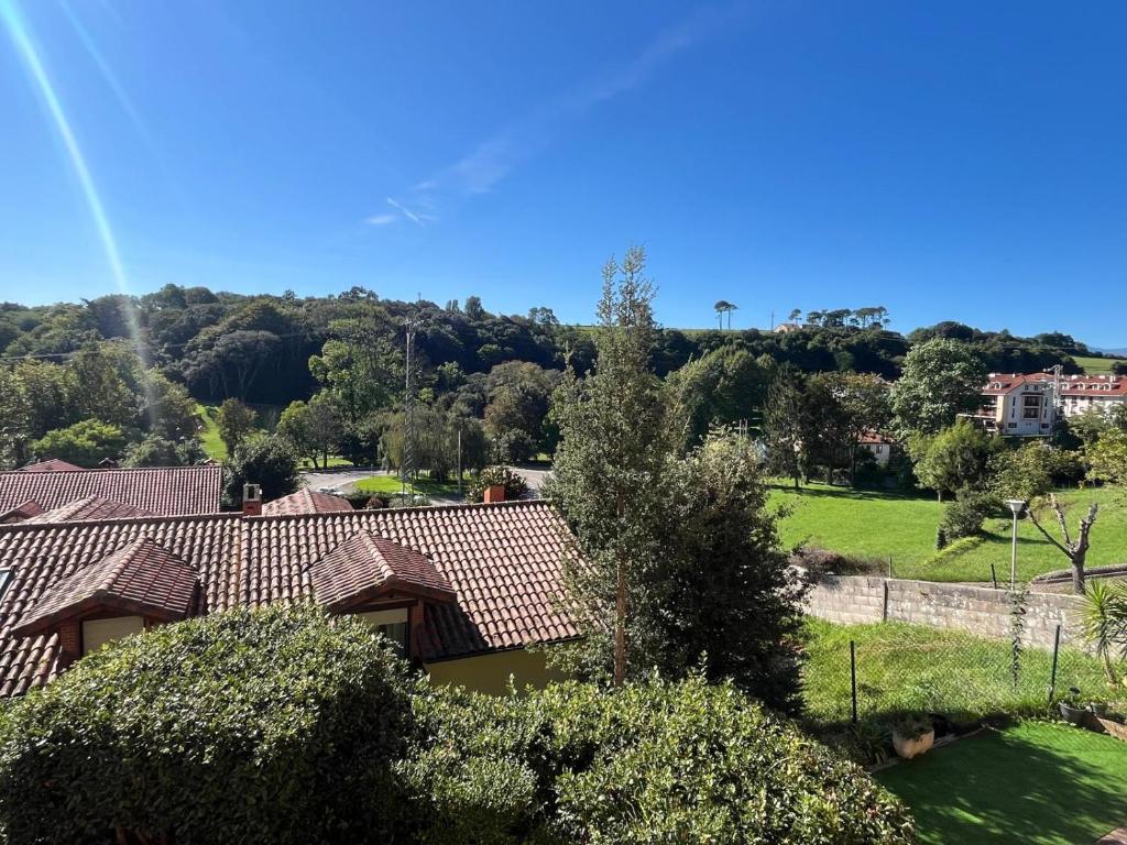 een uitzicht op een huis met bomen en een veld bij La Cardosa in Comillas