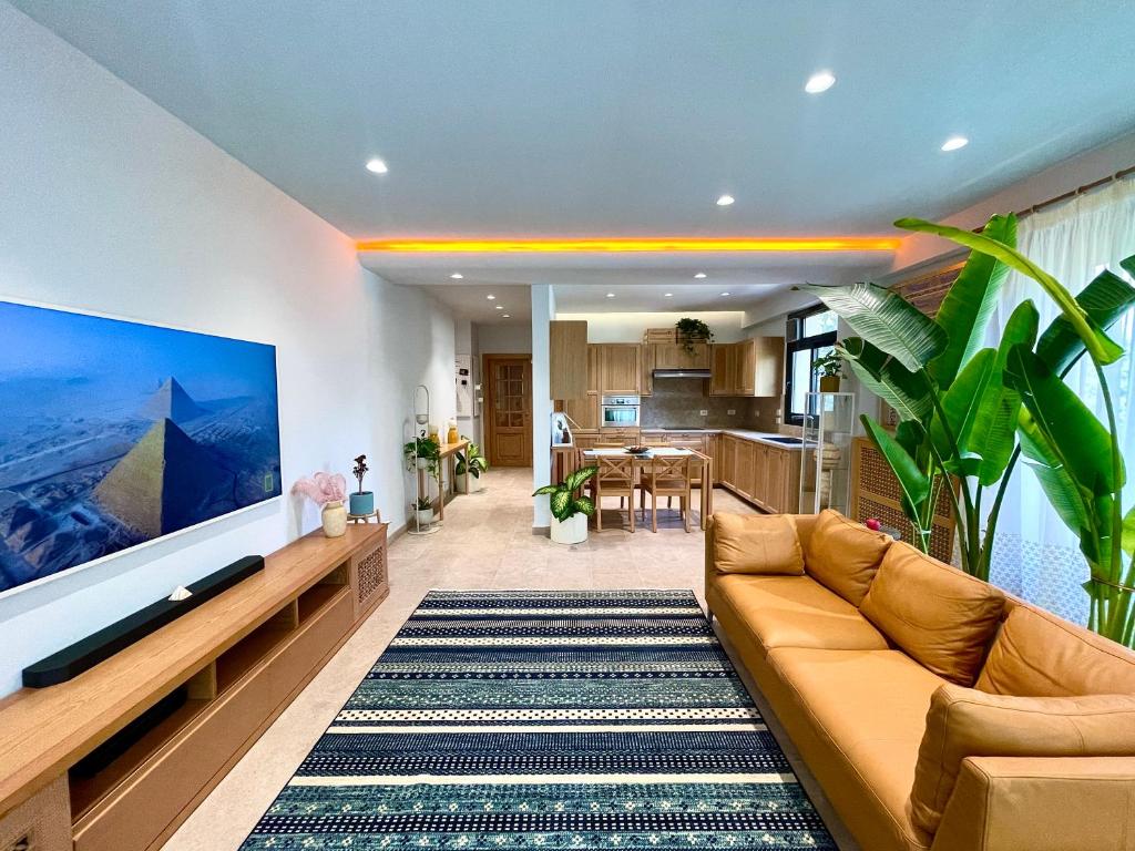 a living room with a couch and a kitchen at AARU Maadi Luxe Retreat in Cairo