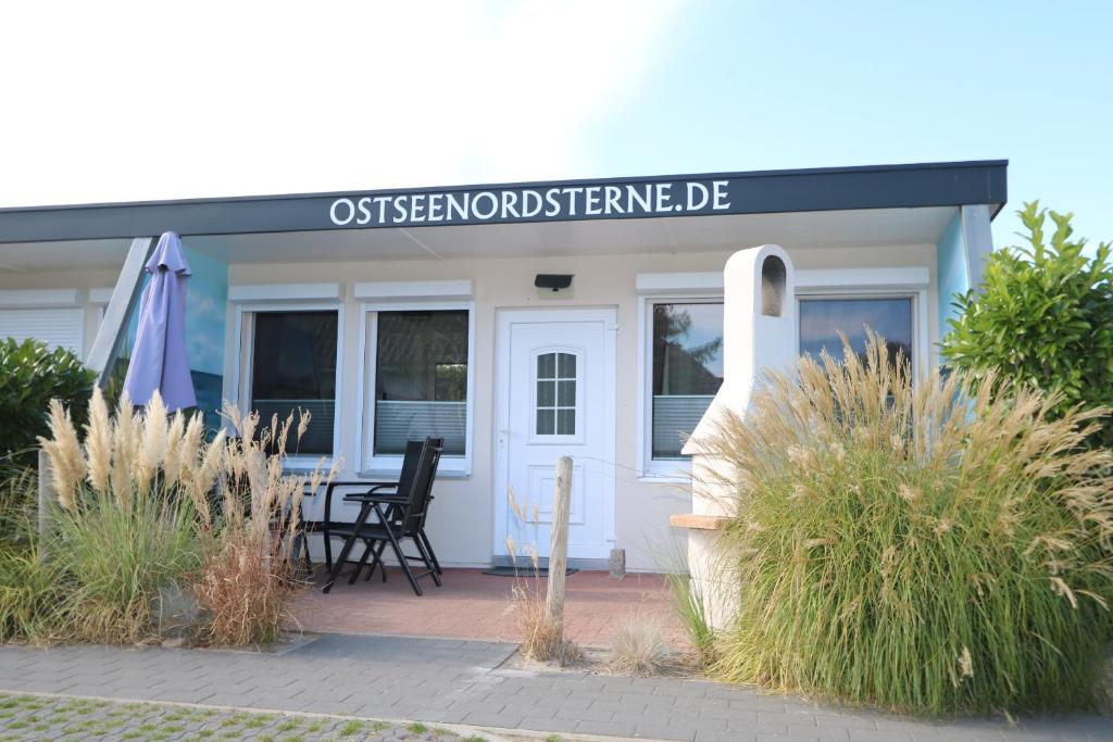a house with a sign on the front of it at Bungalow-Park Ostseenordstern in Wustrow