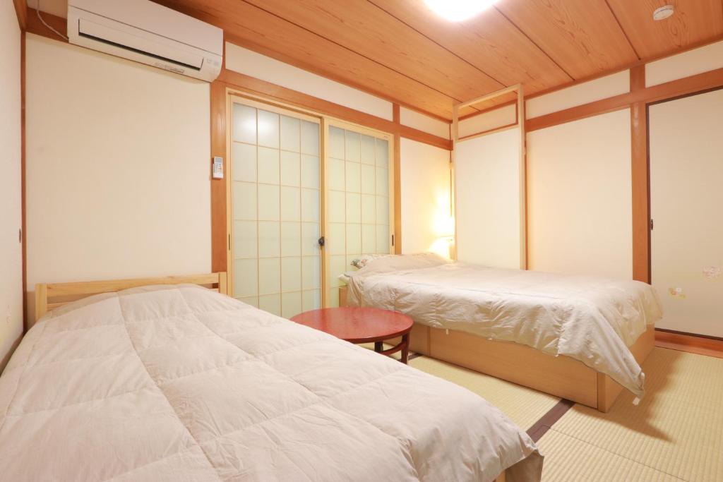 Postel nebo postele na pokoji v ubytování 笑いあふれる乾杯を 小さなホテル ミセス マルベリー