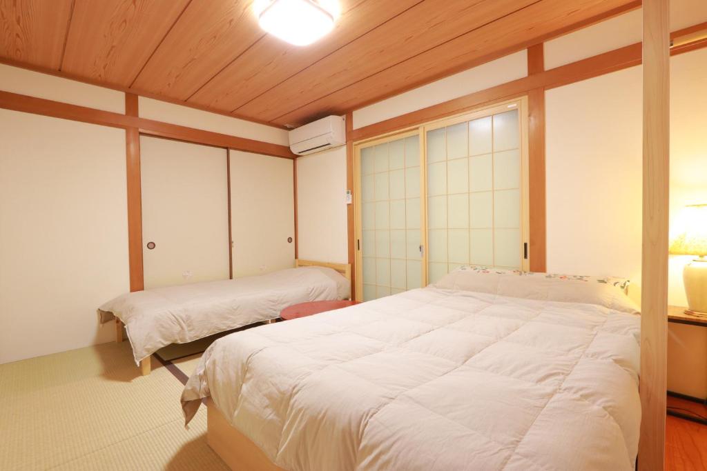 Postel nebo postele na pokoji v ubytování 笑いあふれる乾杯を 小さなホテル ミセス マルベリー
