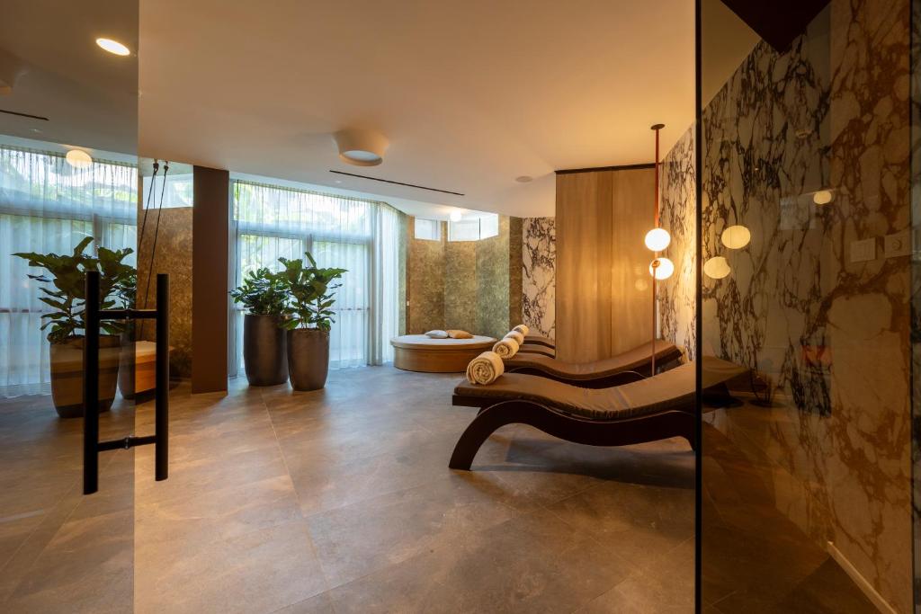 łazienka z wanną i ławką w pokoju w obiekcie Palace Hotel Città w Arco