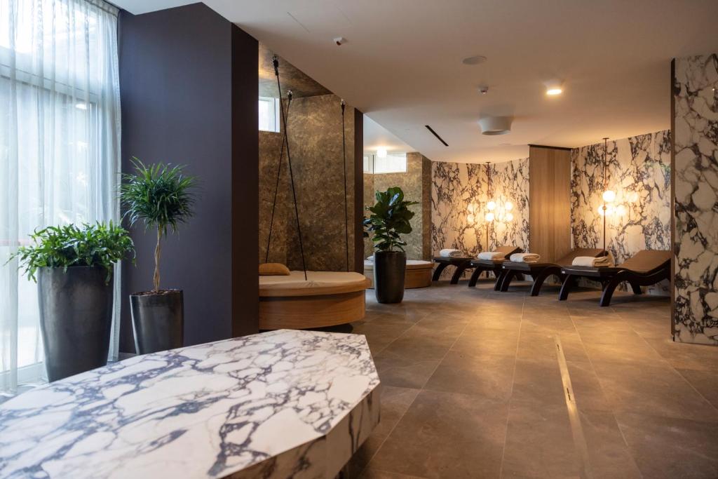 pokój hotelowy z łóżkiem, stołami i roślinami w obiekcie Palace Hotel Città w Arco