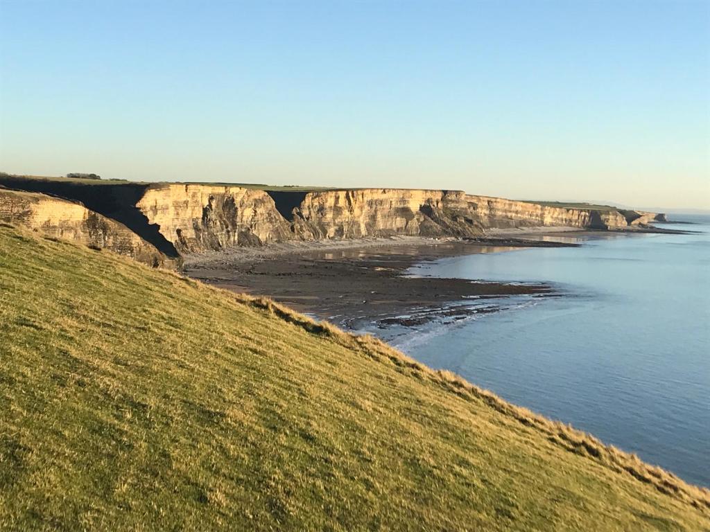 a view of the ocean and a bluff at Woodlands Coastal Apartment in Southerndown