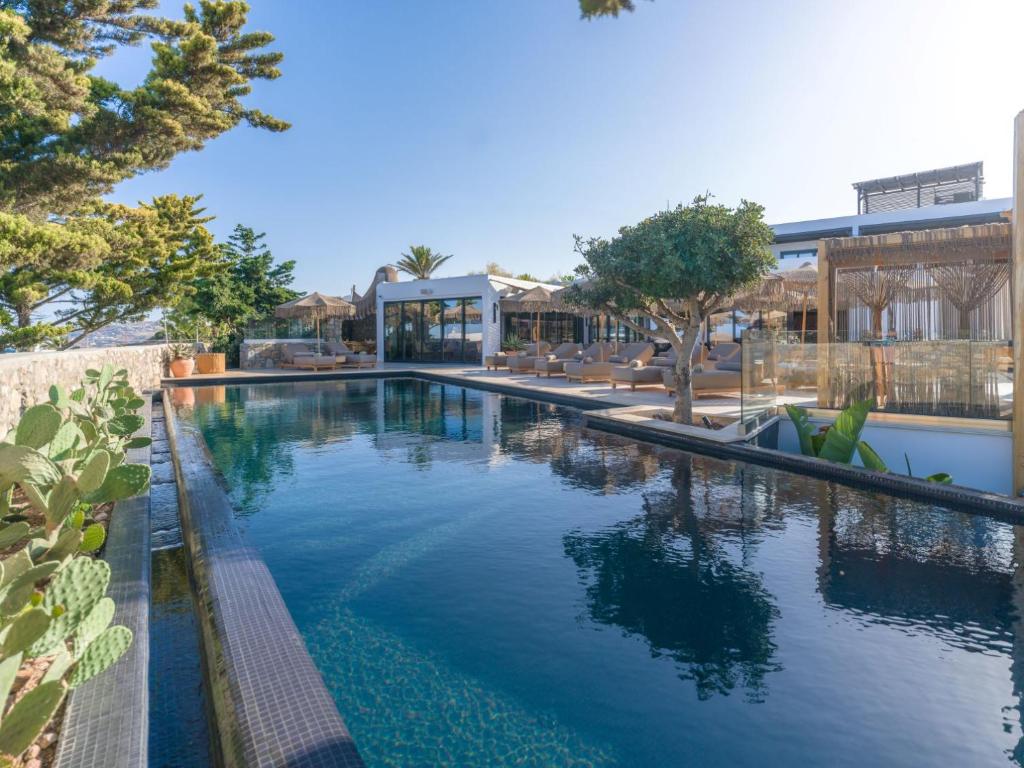 a swimming pool with trees and a building at Asty Mykonos Hotel & Spa - World of One Hotel Group in Mikonos