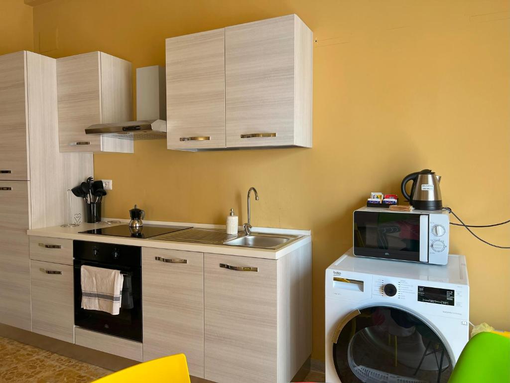 a kitchen with a washing machine and a microwave at Apartment Sonnino 37 in Cagliari