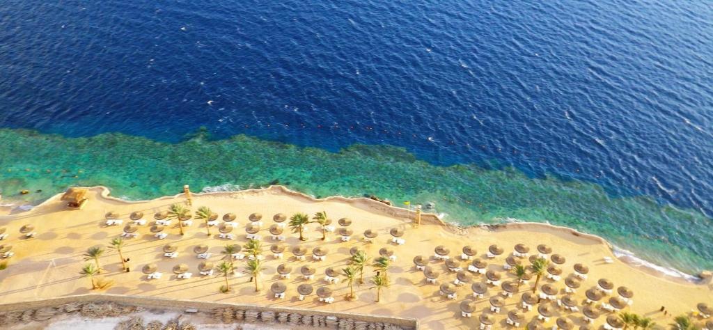 an aerial view of a beach with umbrellas and the ocean at Reef Oasis Blue Bay Resort & Spa in Sharm El Sheikh