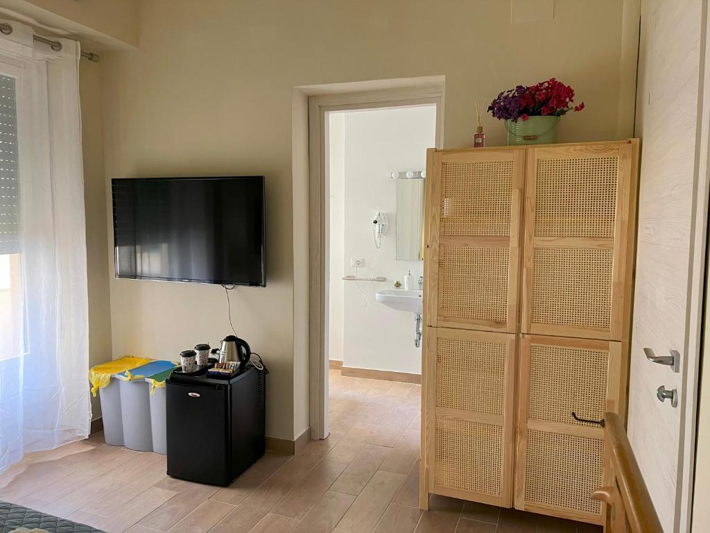 a room with a television on the wall and a refrigerator at Apartment Sonnino 37 in Cagliari