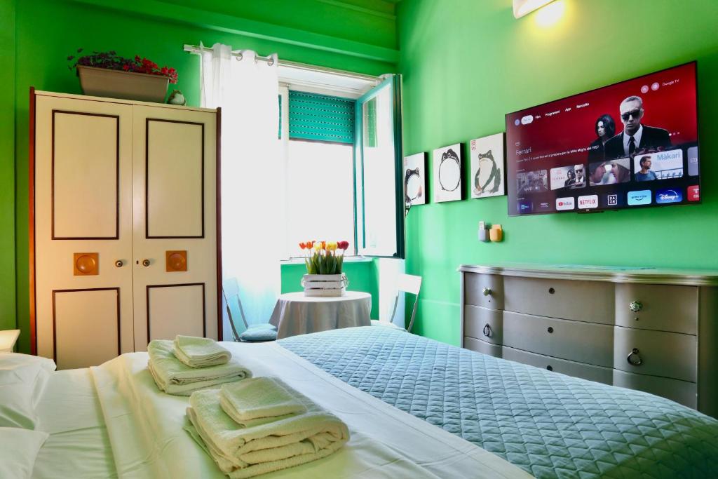 a green bedroom with a bed and a tv on the wall at Apartment Sonnino 37 in Cagliari