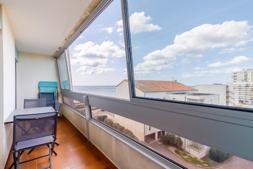 Elle comprend un balcon avec un bureau et une vue sur l'océan. dans l'établissement Vue sur la Plage des Demoiselles - Appt vue mer, à Saint-Hilaire-de-Riez