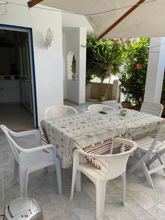 una mesa y sillas blancas con mesa, mesa y sillas en Évasion en bord de mer, en Nabeul