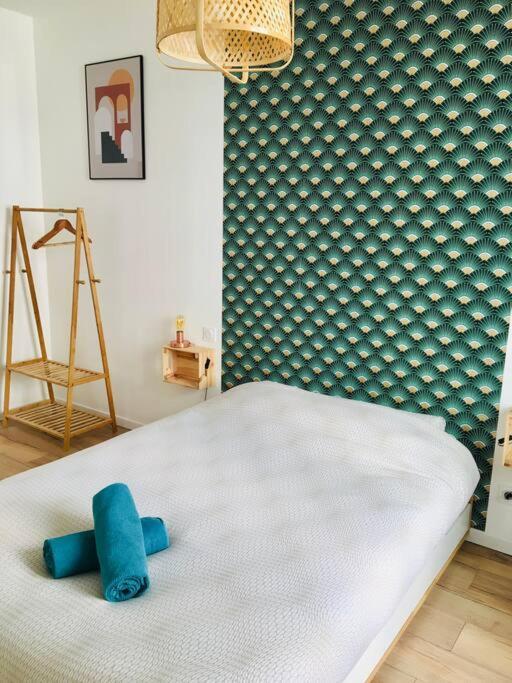 - une chambre dotée d'un lit blanc avec des oreillers bleus dans l'établissement Le Dupont, 2 chambres & Parking privé, à Grenoble