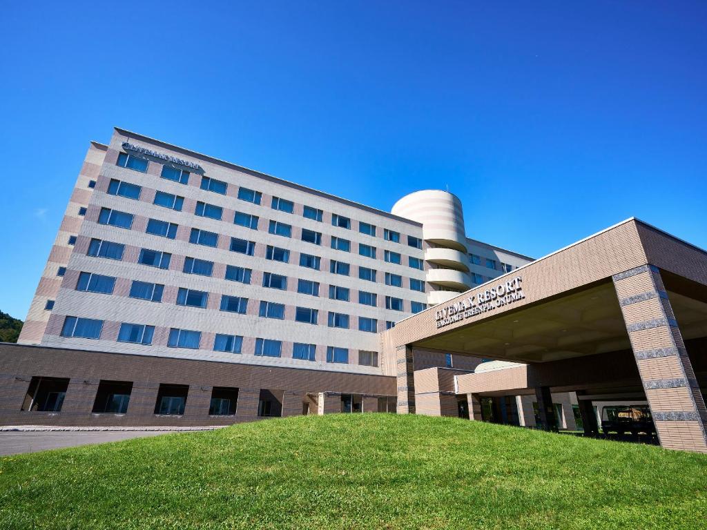 a large building with a lawn in front of it at LiVEMAX RESORT Hakodate Greenpia Onuma in Mori