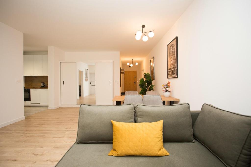 a living room with a gray couch with a yellow pillow at Apartament Bellissima in Bielsko-Biala