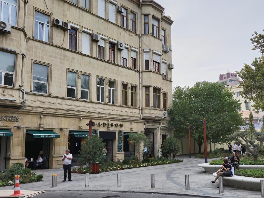 Ein Gebäude mit Leuten, die davor sitzen. in der Unterkunft City center Apartment 14 in Baku