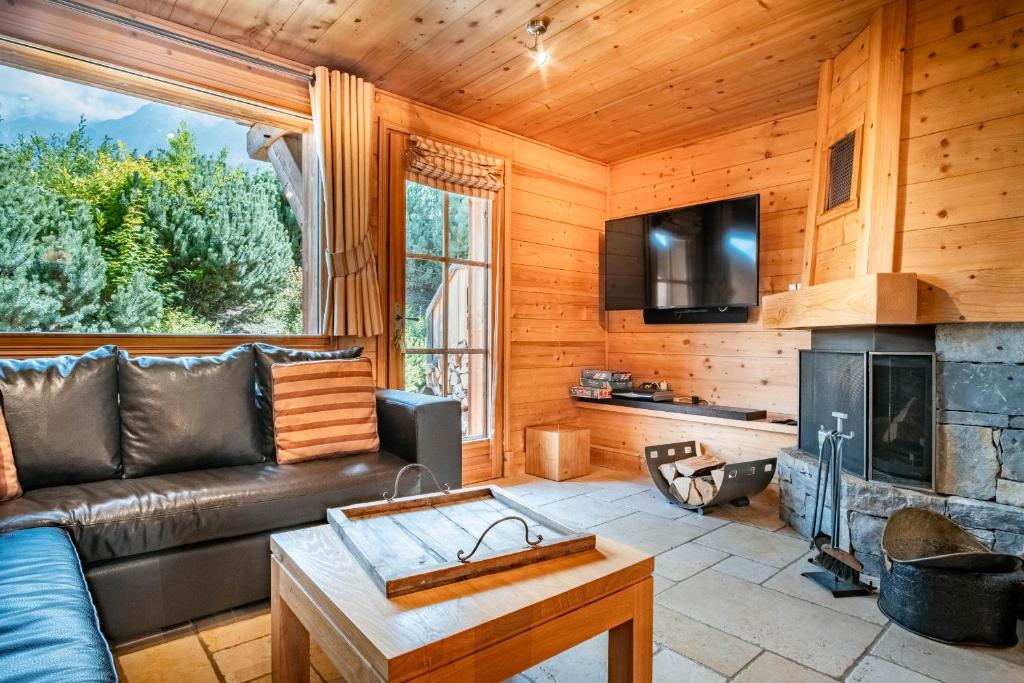 un salon avec un canapé et une cheminée dans l'établissement Maison Neuve 3 - Proche des pistes - Vue, aux Houches