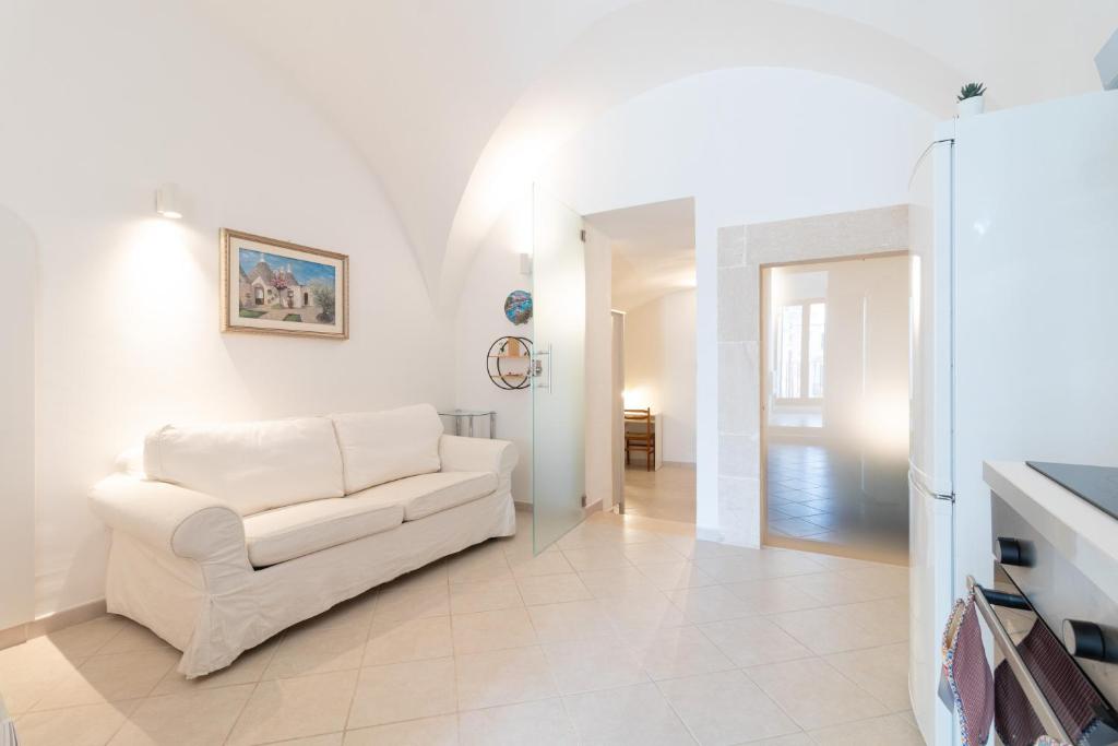 a living room with a white couch and a table at La Greca 59 in Putignano