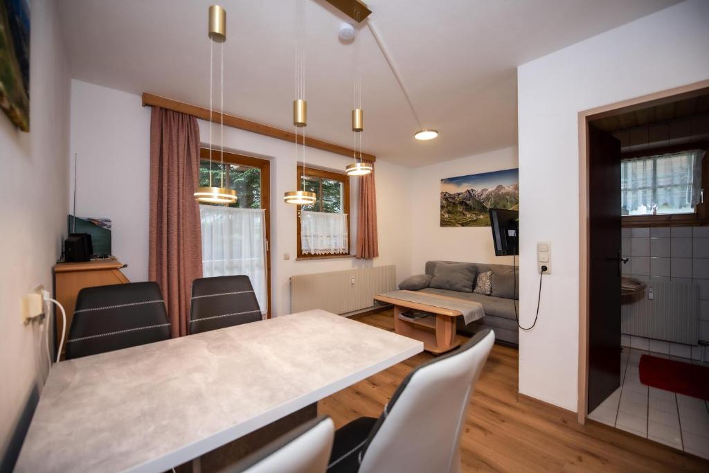 een keuken en woonkamer met een tafel en stoelen bij Chalet Alpine Royal B Top 20 in Krimml