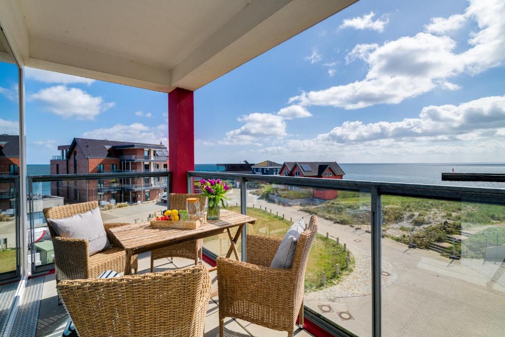 a balcony with a table and chairs and a view of the ocean at Ferienwohnung Meermarie Olpenitz in Olpenitz