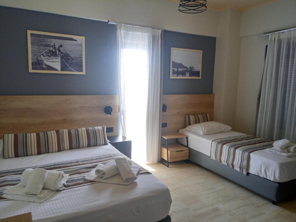 a bedroom with two beds and a window at Horizon Beach Hotel in Plakias