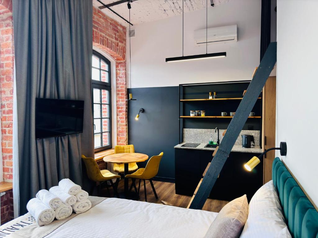 a room with a bed and a table with chairs at Tkalnia Snu in Łódź