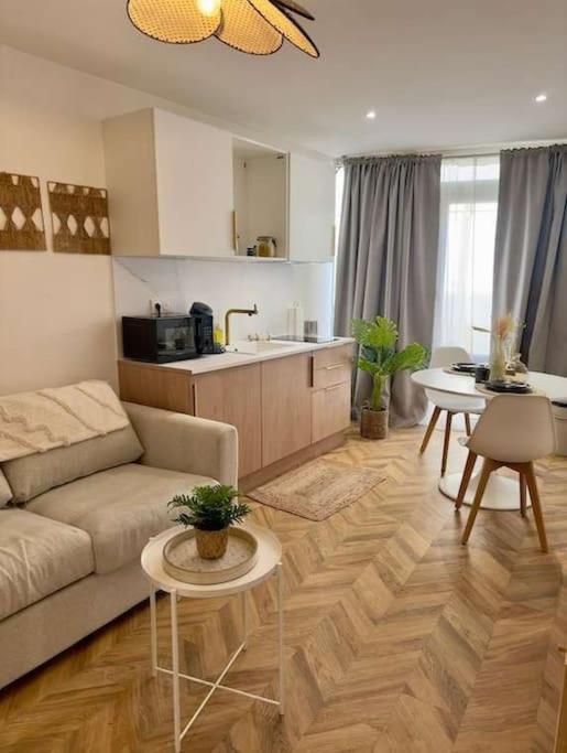 un salon avec un canapé et une cuisine dans l'établissement La Siesta - Jacuzzi et Cozy, à Cholet