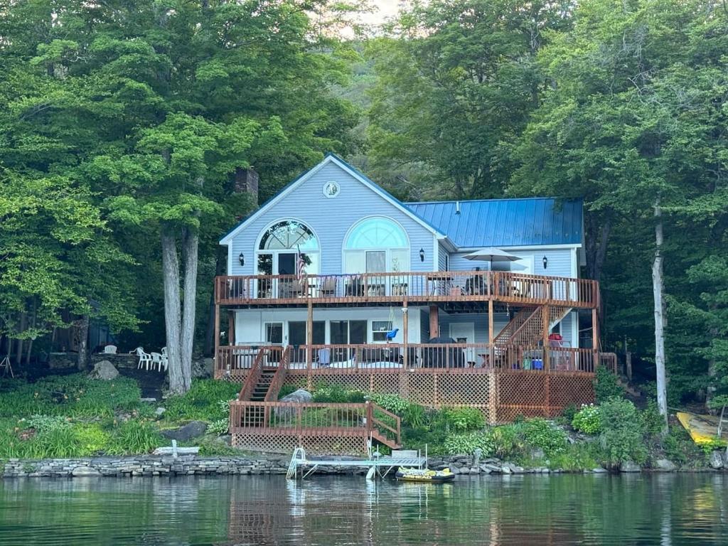 a house with a large deck on the water at Four Season Ski, Lake, And Golf Chalet on Lake Rescue in Tyson