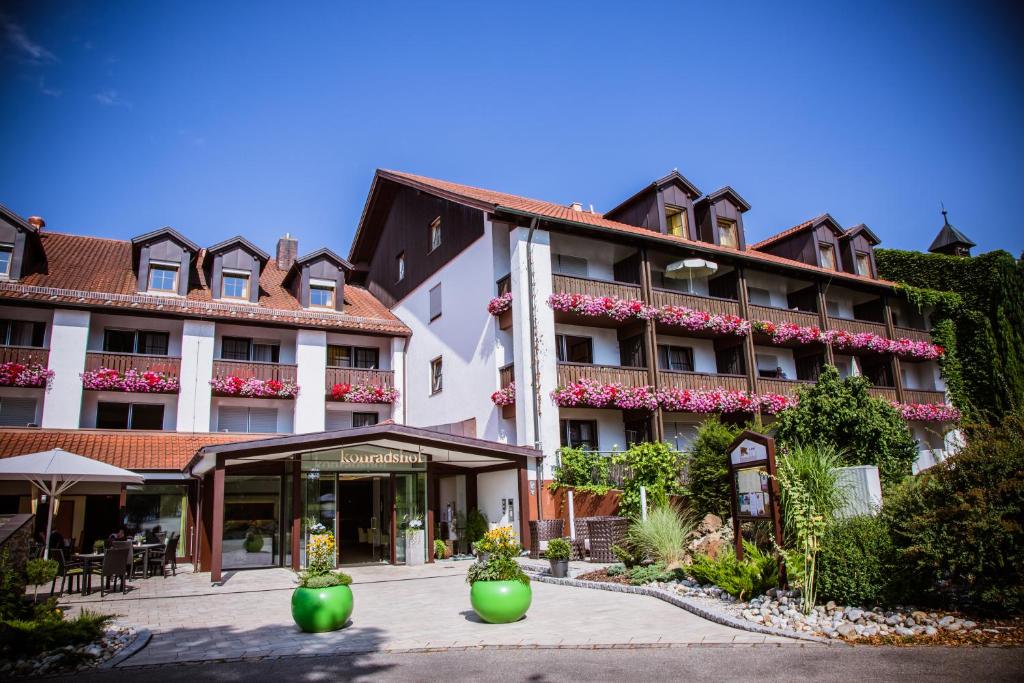 ein großes Gebäude mit Blumen davor in der Unterkunft Hotel Konradshof in Bad Griesbach