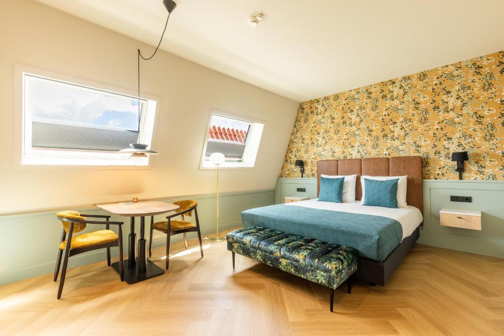 een slaapkamer met een bed en een tafel in een kamer bij Boutiquehotel het Eiland in Oost-Vlieland