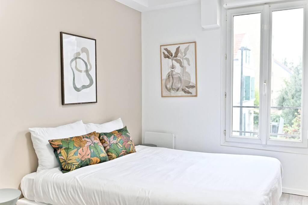 une chambre blanche avec un lit blanc et une fenêtre dans l'établissement Petit studio moderne à Asnières, à Asnières-sur-Seine
