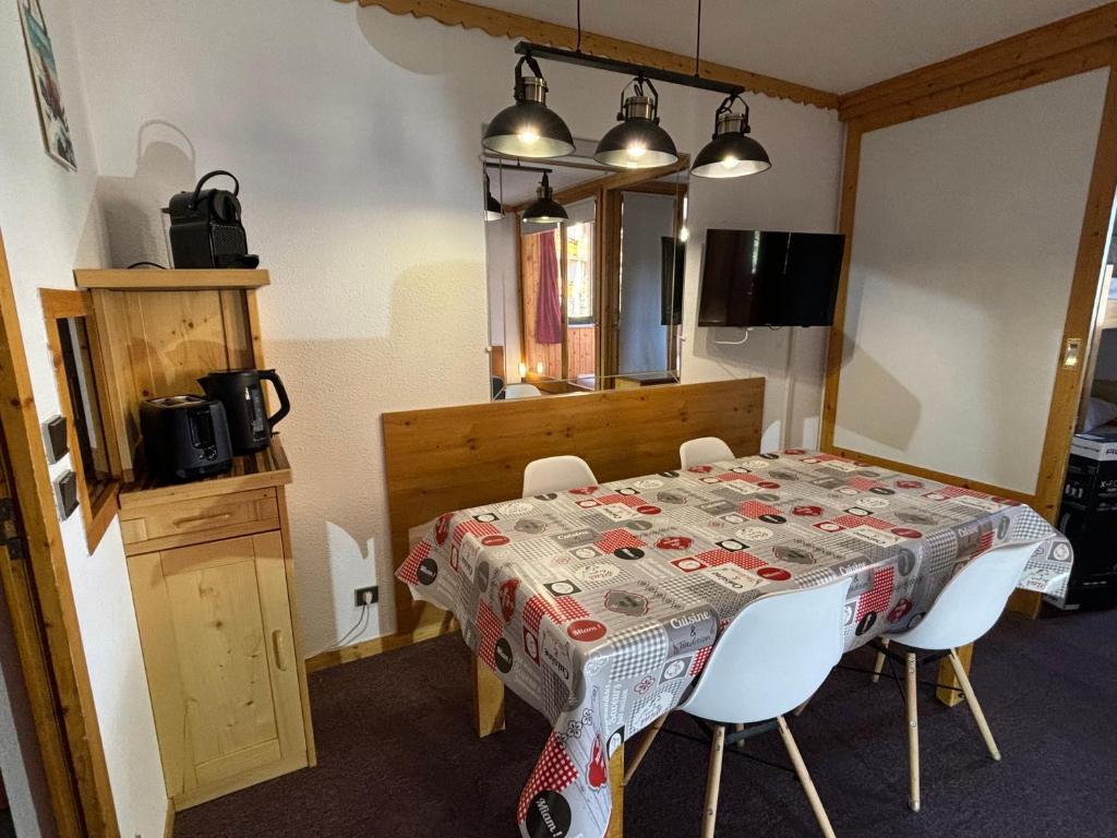 a dining room table with chairs and a tablecloth on it at Appartement Eskival skis aux pieds in Val Thorens