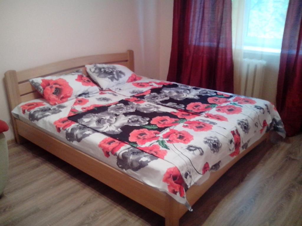 a bedroom with a bed with a floral comforter at Apartment Syrec in Kyiv