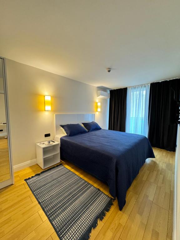 a bedroom with a blue bed and a mirror at EVIS LTD apartments Batumi 2 in Angisa