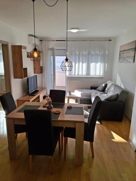 una sala de estar con una mesa y un sofá en Apartman Nina, en Špansko