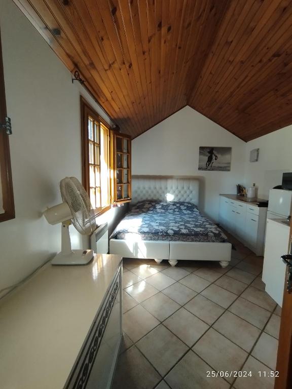 une chambre avec un lit et un plafond en bois dans l'établissement Studio pas loin de Disney 15 min en voiture, à Chanteloup-en-Brie