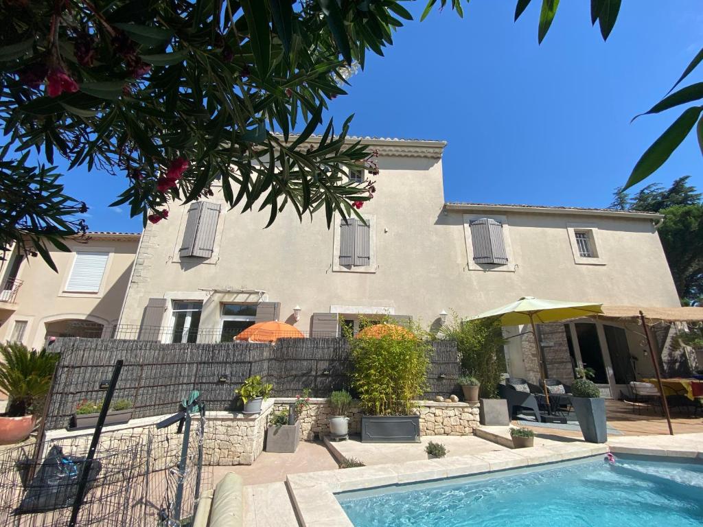 une maison avec une piscine devant dans l'établissement La Papaline de Caroline Suite chambre d'hôtes avec petit-déjeuner Saint-Saturnin-lès-Avignon, à Saint-Saturnin-lès-Avignon