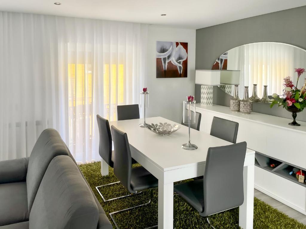 a dining room with a white table and chairs at Guesthouse Santos & Belos in Nazaré