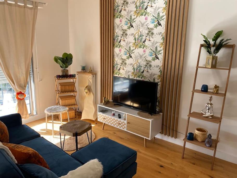 un salon avec un canapé bleu et une télévision dans l'établissement Vue dégagée au calme dernier etage, à Mérignac