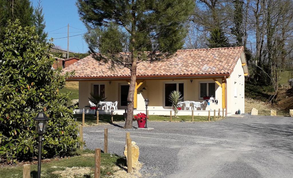 une maison jaune avec un arbre devant elle dans l'établissement MF 9 et MF 10, à Cazaubon