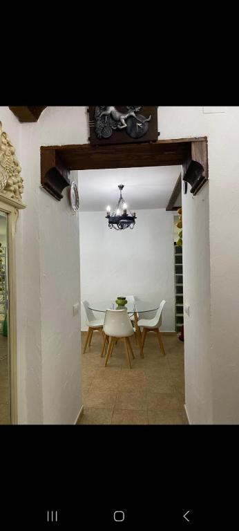 a dining room with a table and chairs and a chandelier at Apartamento Donna Elvira in Caserío Bogás
