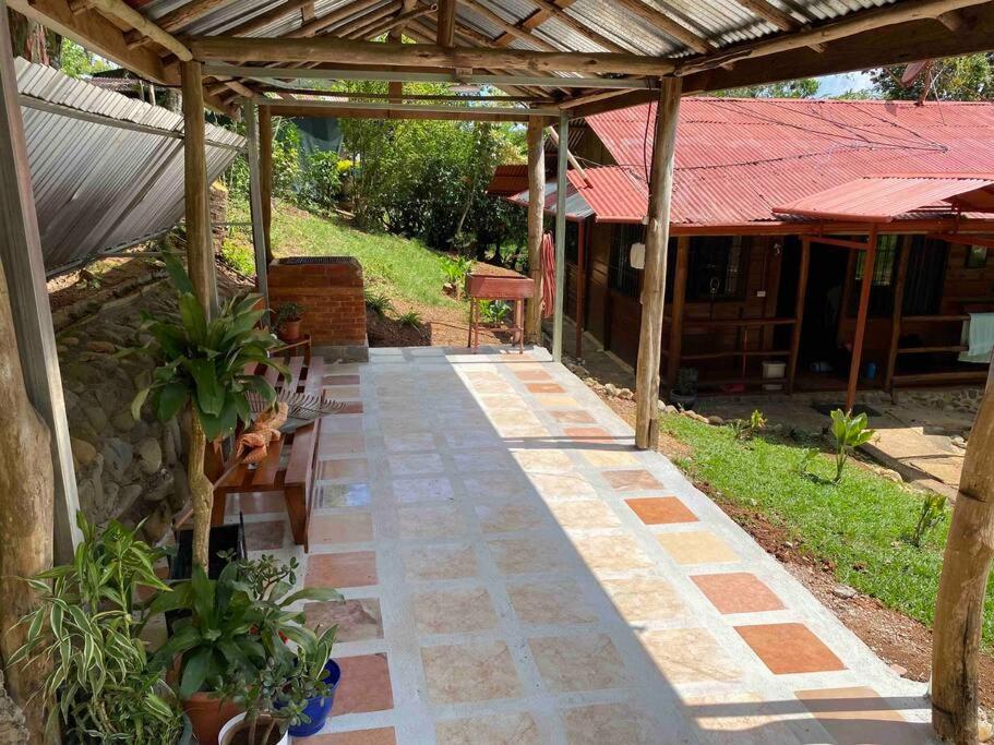 a stone walkway leading to a house with a roof at Hermosa Cabaña equipada, en medio de zonas verdes in Pedregoso