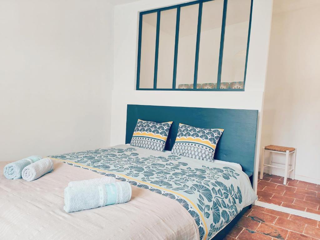 une chambre avec un lit avec une tête de lit bleue dans l'établissement Maison La belle de Cadenet proche Lourmarin, à Cadenet