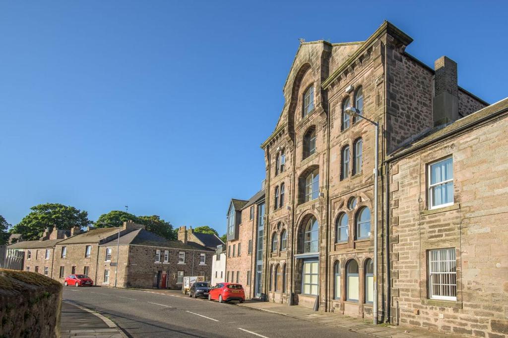 un viejo edificio de ladrillo al lado de una calle en Mill Wharf en Berwick-Upon-Tweed