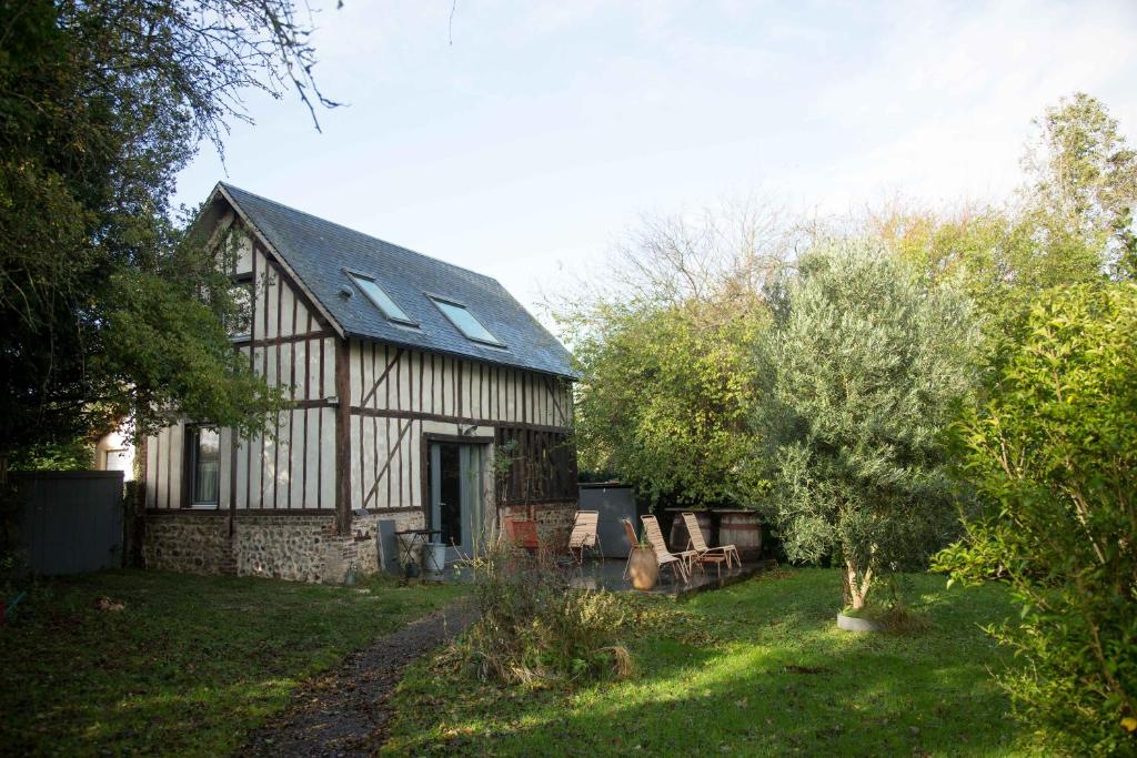 une maison avec un toit en gambrel dans une cour dans l'établissement La Bergerie, à Fatouville-Grestain