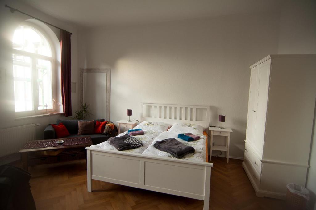 ein Schlafzimmer mit einem Bett, einem Sofa und einem Fenster in der Unterkunft Apartment Altstadt Villa in Quedlinburg