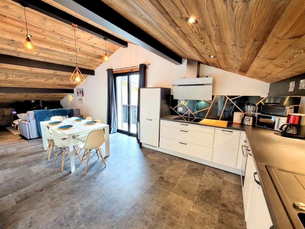 une cuisine et une salle à manger avec une table et des chaises dans l'établissement Appartement lumineux 2 suites, proche pistes et au calme - Les Gets - FR-1-598-173, aux Gets