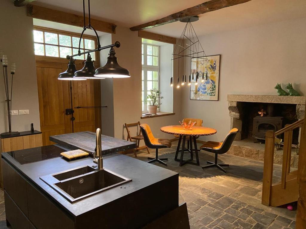 una cucina con lavandino e tavolo con tavolo di Garden Cottage Kervolongar a Garlan